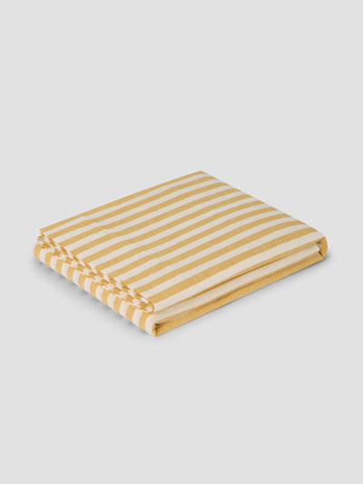 Folded yellow and white striped fabric on a light gray background