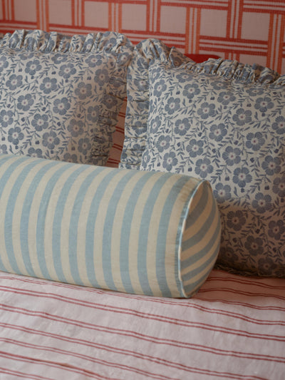 Dusk Blue Folk Floral Frill Linen Blend Filled Cushions and Coastal Blue Pembroke Stripe Bolster Cushion on a red and white checkered background.