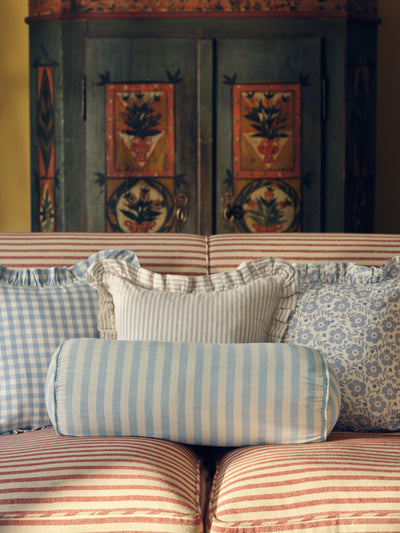Decorative pillows on a sofa with a patterned wall in the background